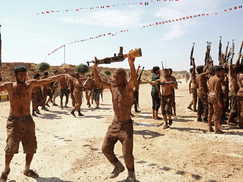 Syrian Turkish-backed fighters from al-Mutasim Brigade react after finishing their training at a camp near the town of Marea in Syria's northern Aleppo district, on September 12, 2019. Nazeer Al-khatib / AFP