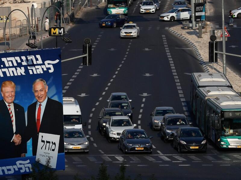 Traffic drives past an Israeli election billboard for the Likud party, showing US President Donald Trump (L) shaking hands with Likud chairman and Prime Minister Benjamin Netanyahu in Jerusalem AHMAD GHARABLI / AFP