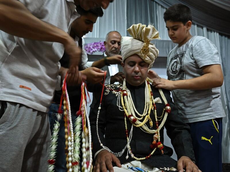 In this photo taken on September 15, 2019, a groom is garlanded by relatives and friends before leaving for his bride's home in Kashmir's Baramulla district, north of Srinagar. TAUSEEF MUSTAFA / AFP