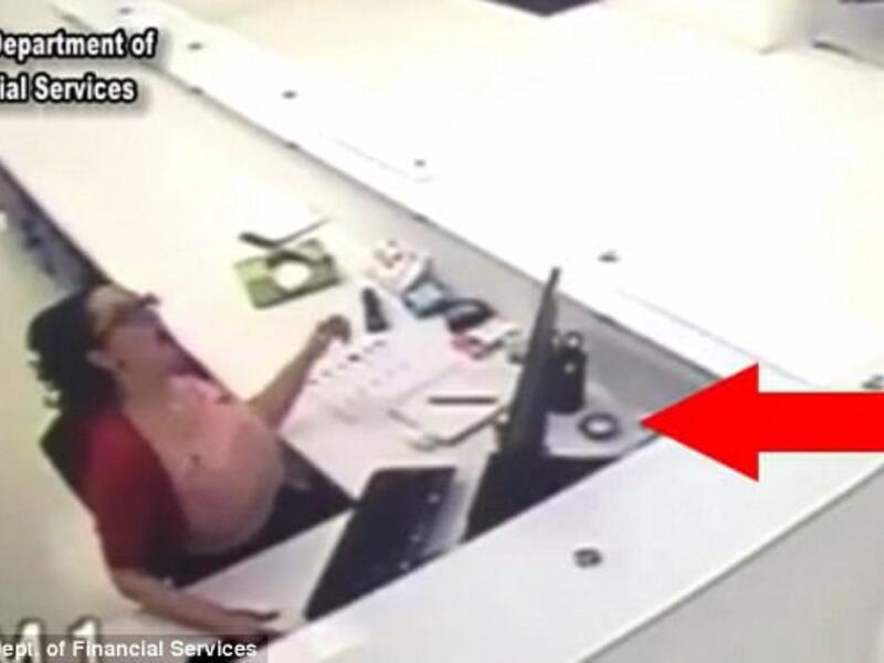 Sheyla White tried to fake a workplace injury after a sprinkler head fell onto her desk (indicated by the red arrow). She said it bounced up and hit her. (Screenshot/ Video)