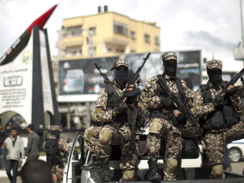 Members of Hamas's military wing pose in front of a M-75 rocket in Gaza. (AFP/ File Photo)