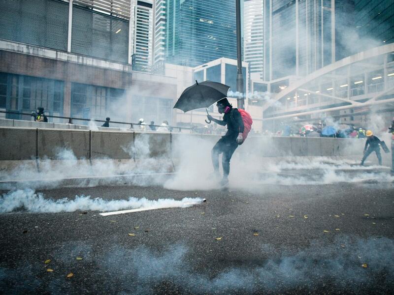 Protesters react after police fired tear gas outside the government headquarters in Hong Kong (AFP)
