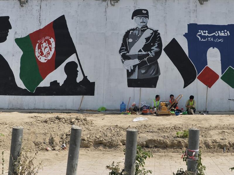 Workers take rest next to a mural of late king of Afghanistan Aman Ullah Khan, who led the successful war for Afghanistan's independence from British Rule in 1919, the day after Afghanistan held presidential elections, in Kabul on September 29, 2019. (AFP/ File Photo)