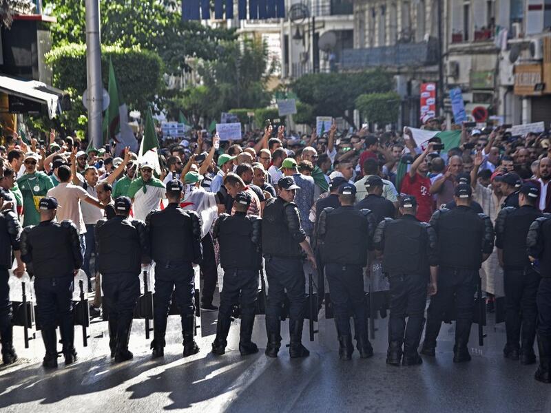 Algerian protesters face riot police during a demonstration against the ruling class in the capital Algiers on October 4, 2019, for the 33rd consecutive Friday since the movement began. (RYAD KRAMDI / AFP)