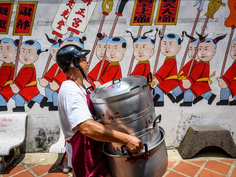 A volunteer carries empty pots at a Chinese shrine during the annual Vegetarian Festival in Phuket on October 5, 2019. Mladen ANTONOV / AFP