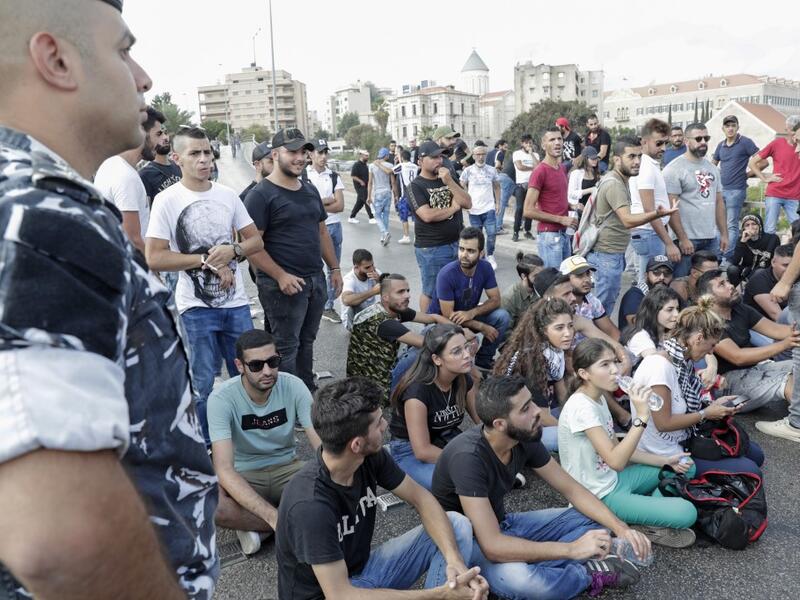 Lebanese protesters try to block a road during a demonstration near central Beirut's Martyr Square on October 6, 2019. Lebanese protested in the capital over increasingly difficult living conditions, amid fears of a dollar shortage and possible price hikes. ANWAR AMRO / AFP