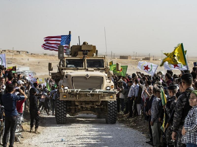 Syrian Kurds gather around a US armoured vehicle during a demonstration against Turkish threats next to a US-led international coalition base on the outskirts of Ras al-Ain town in Syria's Hasakeh province near the Turkish border on October 6, 2019. (AFP/ File Photo)