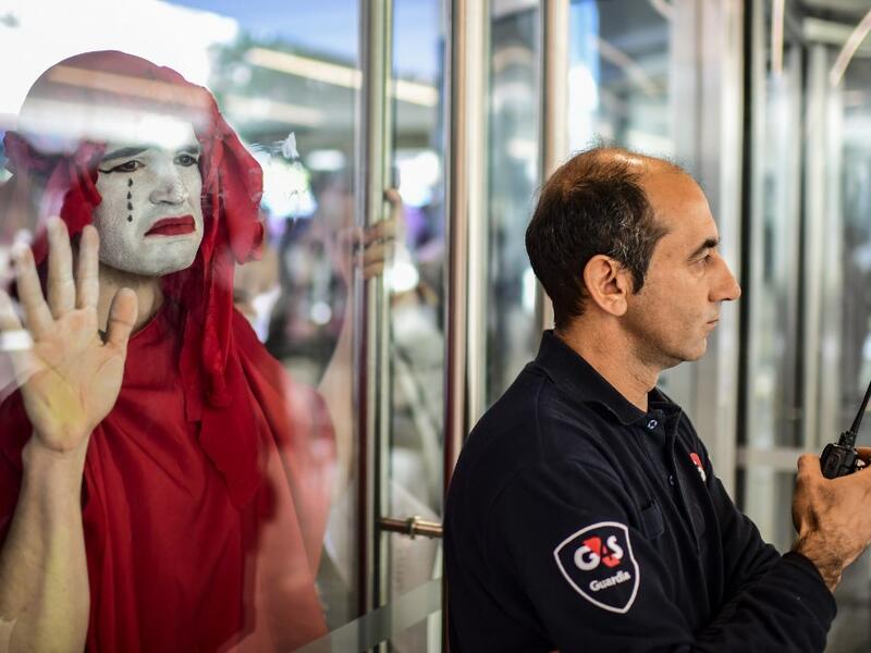 A protestor (L) takes part in a demonstration called by climate change activist group Extinction Rebellion, in front of the lobby of the building where the Bayer-Monsanto office is located in Buenos Aires on October 7, 2019. The year-old group Extinction Rebellion has energised a global movement demanding governments drastically cut the carbon emissions that scientists have shown to cause devastating climate change. RONALDO SCHEMIDT / AFP
