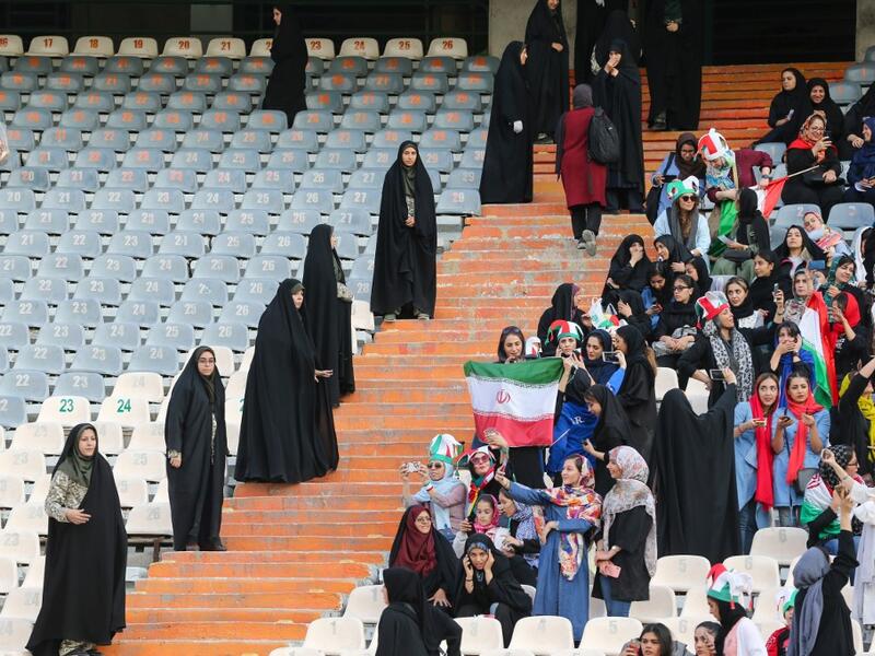 Iranian women cheer and wave their country's national flags as they attend the World Cup Qatar 2022 Group C qualification football match between Iran and Cambodia at the Azadi stadium in the capital Tehran on October 10, 2019. ATTA KENARE / AFP