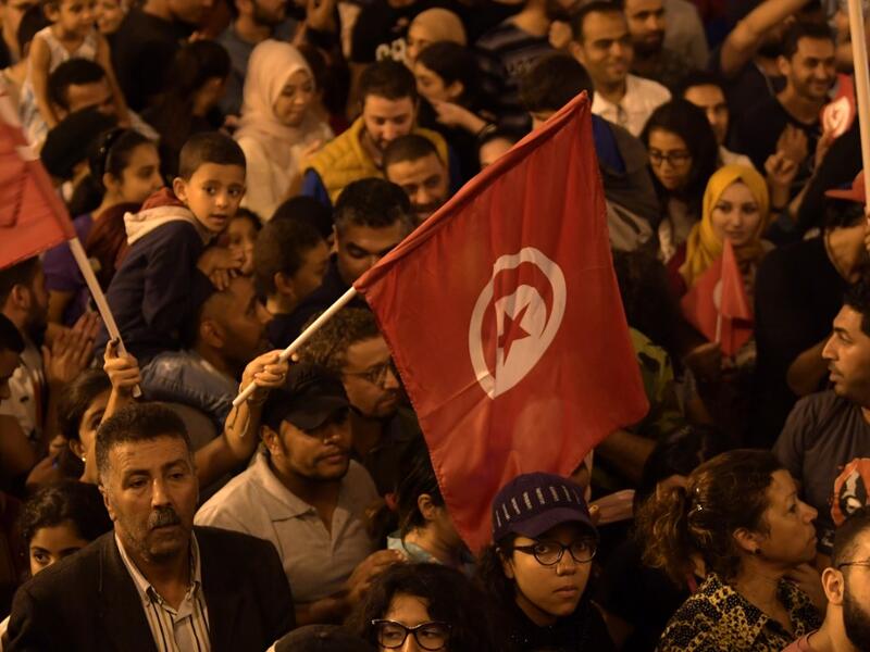 Tunisians gather to celebrate the victory of Kais Saied in the Tunisia's presidential runoff on October 13, 2019, in the capital Tunis. Conservative academic Kais Saied, a political outsider, won a landslide victory Sunday in Tunisia's presidential runoff, sweeping aside his rival, media magnate Nabil Karoui, state television said. Fethi Belaid / AFP