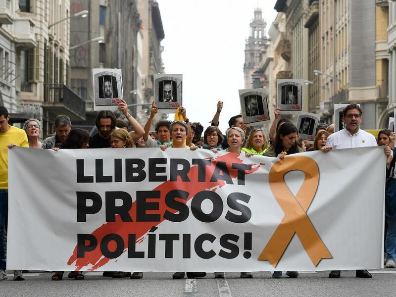 People protest holding a banner reading "Free political prisoners" in Barcelona on October 14, 2019, after Spain's Supreme Court sentenced nine Catalan leaders to prison terms ranging from nine to 13 years for sedition and misuse of public funds for their role in a failed 2017 independence bid. (LLUIS GENE / AFP)