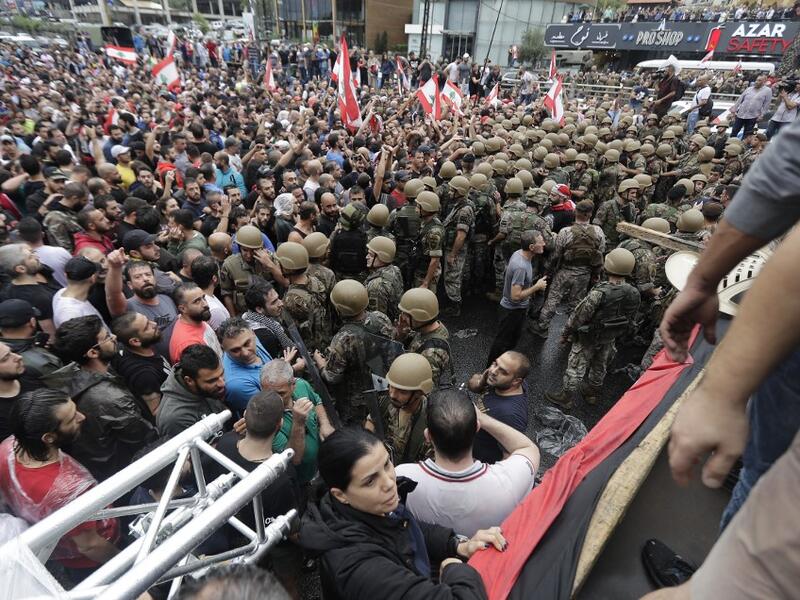 Lebanese protesters stand facing army soldiers after they deployed on main roads to remove road blocks set up by demonstrators on October 23, 2019, in the area of Zouk Mosbeh north of the capital Beirut.  (AFP/ File Photo)