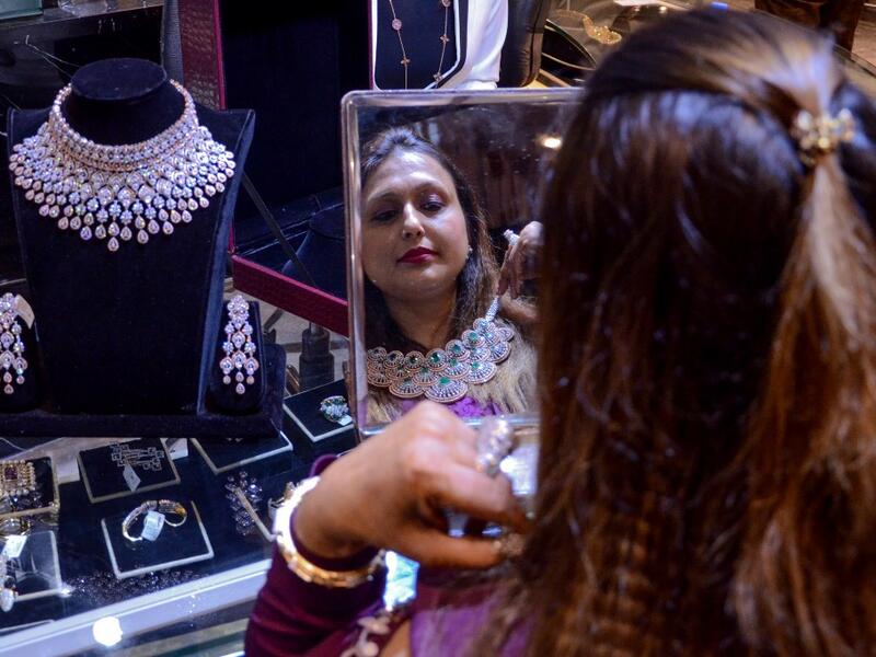 A customer tries on gold jewellery at a store in Amritsar on October 25, 2019. Dhanteras, the first day to mark the Hindu festival of Diwali, is seen as an auspicious day on which to make purchases. NARINDER NANU / AFP
