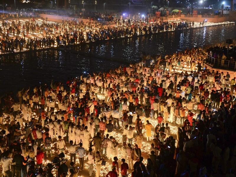 Hindu devotees light earthen lamps on the banks of the River Sarayu on the eve of "Diwali" festival during an event organised by the Uttar Pradesh government, in Ayodhya on October 26, 2019. "Diwali", the Festival of Lights, marks victory over evil and commemorates the time when Hindu god Lord Rama achieved victory over Ravana and returned to his kingdom Ayodhya. SANJAY KANOJIA / AFP