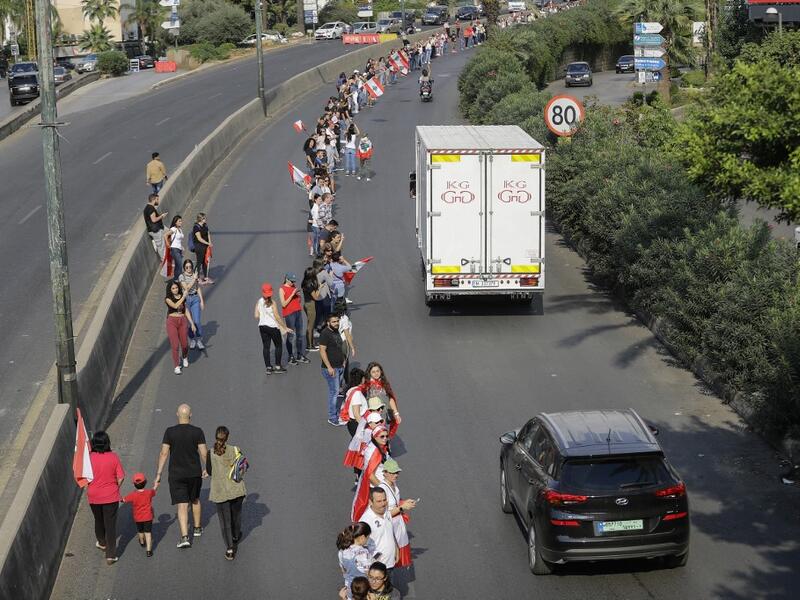 Lebanese protesters hold hands to form a human chain along the coast from north to south as a symbol of unity during ongoing anti-government demonstrations on Jounieh highway north of Lebanon's capital Beirut on October 27, 2019. JOSEPH EID / AFP