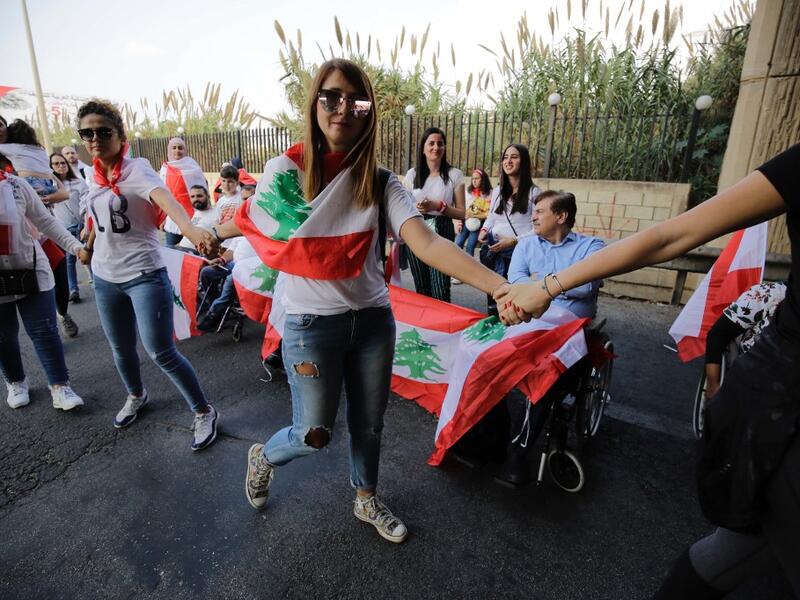 Lebanese protesters hold hands to form a human chain along the coast from north to south as a symbol of unity, during ongoing anti-government demonstrations in Lebanon's northern city of Tripoli on October 27, 2019. Ibrahim CHALHOUB / AFP
