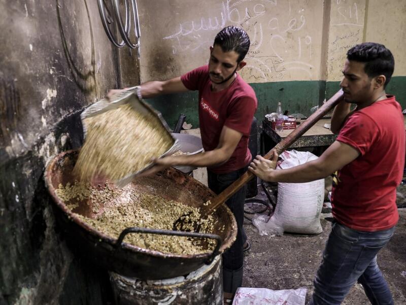 Egyptian confectioners add peanuts to melted sugar as they make sweets at a candy factory in the capital Cairo on November 2, 2019, ahead of celebrations of the Muslim Prophet Mohammed's birthday, known as "Al Mawlid Al Nabawi". Prophet Mohamed was born in Saudi Arabia's arid mountainous city of Mecca, the holiest in Islam, some 1490 years ago. Sunni Muslims in many parts of the world celebrate his birthday on the 12th day of the third month of the Islamic calendar, which will fall this year on November 9th