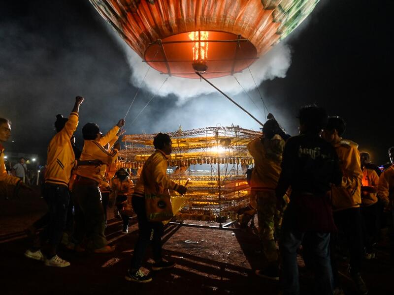 This picture taken on November 4, 2019 shows participants releasing a hot-air balloon attached with fireworks during the Tazaungdaing Lighting Festival at Taunggyi in Myanmar's northeastern Shan State. Brightly coloured balloons with hundreds of homemade fireworks woven into their frames are sent soaring into the night sky, showering down cascades of sparks onto adoring crowds in the annual Taunggyi fire balloon festival. Ye Aung THU / AFP