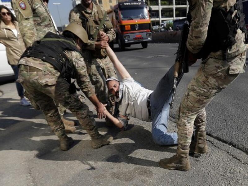 Lebanese army soldiers remove a protester as they open the Tripoli-Beirut highway blocked earlier amid ongoing demonstrations in Zouk Mosbeh, north of the capital Beirut, on November 5, 2019.  (AFP/ File Photo)