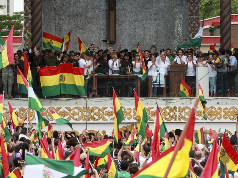 People accompanied by police celebrate the resignation of Bolivian President Evo Morales in Santa Cruz on November 10, 2019. (DANIEL WALKER / AFP)
