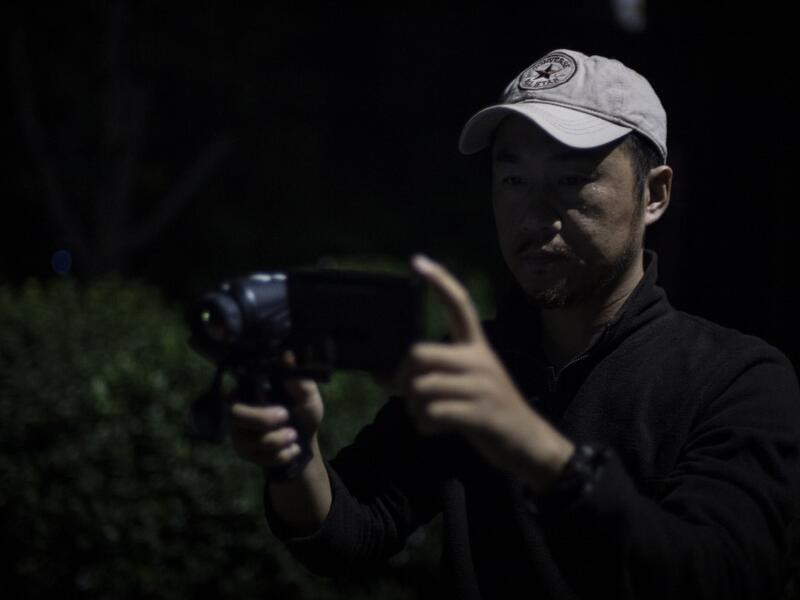 This photo taken on October 23, 2019 shows pet detective Sun Jinrong using a night vision camera as he searches for a missing cat in a residential compound in Beijing. Private sleuth Sun Jinrong brings heat detectors, tiny surveillance cameras, and a blowdart loaded with a tranquiliser to his search for one desperate client's missing loved one: A cat named Duoduo.  NOEL CELIS / AFP