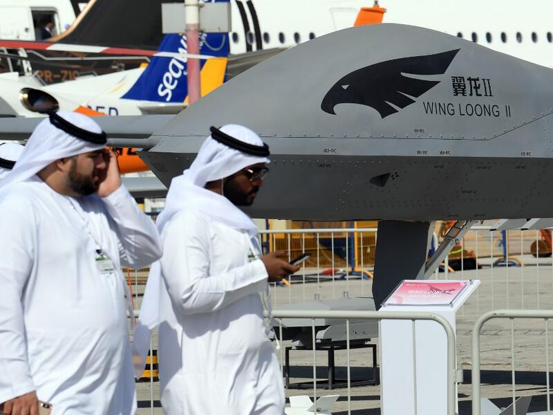 Men walk past a Chinese-made CAIG Wing Loong II medium altitude long endurance (MALE) unmanned aerial vehicle (UAV), on display during the 2019 Dubai Airshow on November 18, 2019. KARIM SAHIB / AFP