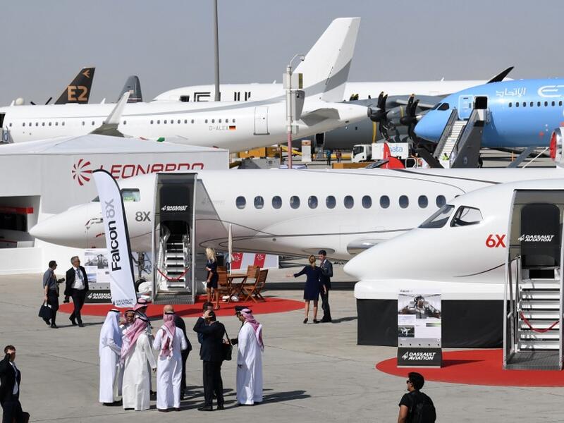 This picture taken on November 18, 2019 shows a general view of visitors walking past aircraft on display during the 2019 Dubai Airshow. KARIM SAHIB / AFP