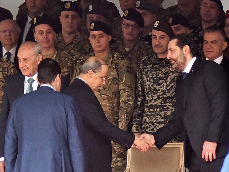Lebanese President Michel Aoun (C) shakes hands with Prime Minister Saad Hariri (R) while Parliament speaker Nabih Berri (L) stands by, as they attend a military parade commemorating the 76th anniversary of Lebanese independence from France. (AFP/ File Photo)