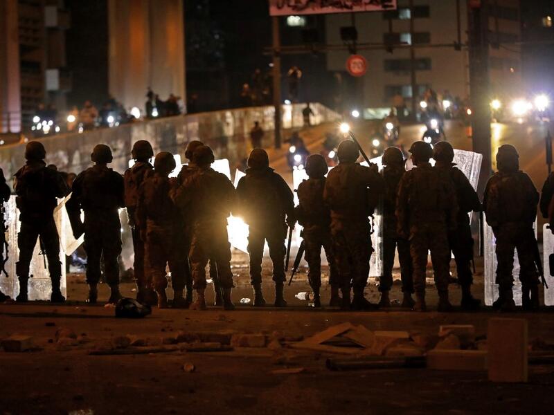 Lebanese army soldiers deploy as supporters of the Shiite Hezbollah and Amal groups arrive on scooters amid clashes with anti-government protesters in the capital Beirut (AFP)