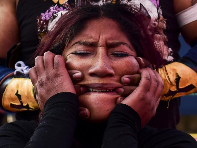 Bolivian wrestler Blanca Perez, aka "Katy The Beautiful", a member of the Fighting Cholitas, fights with a male wrestler at Sharks of the Ring wrestling club in El Alto, Bolivia, on November 24, 2019. After a fortnight hiatus due to anti-government protests and blockades, the Fighting Cholitas are back in the ring. The unrest was triggered by the disputed October 20 election, which Evo Morales claimed to have won and opposition groups said was rigged. Ronaldo SCHEMIDT / AFP