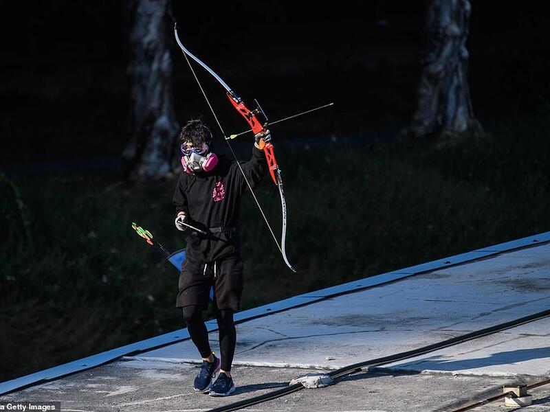 A protester wielding a bow and arrow walks along a footbridge roof. Hong Kong returned to Chinese rule under a 'one country, two systems' formula guaranteeing its colonial-era freedoms. (AFP/ File)