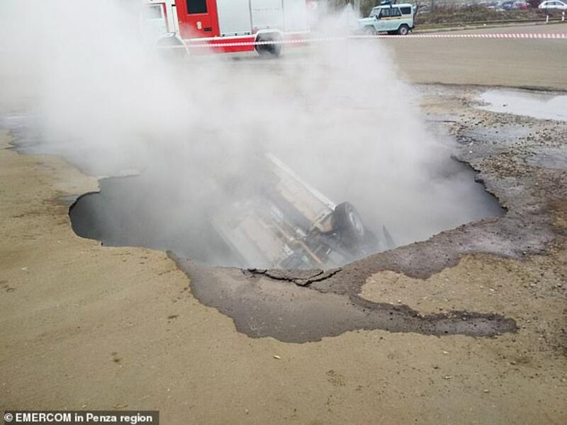 Steam engulfs the car inside the hole in Penza today. 'What an horrendous way to die - one moment you are driving a car, the next underground drowning in hot water,' said one woman. (EMERCOM)