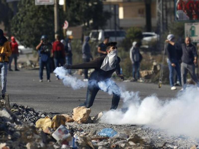 A Palestinian youth uses a slingshot to hurl a stone towards Israeli security forces on November 26, 2019 during clashes in the West Bank city of Hebron as Palestinians stage a "day of rage" against a recent US decision to no longer consider settlements in the West Bank illegal (Twitter)
