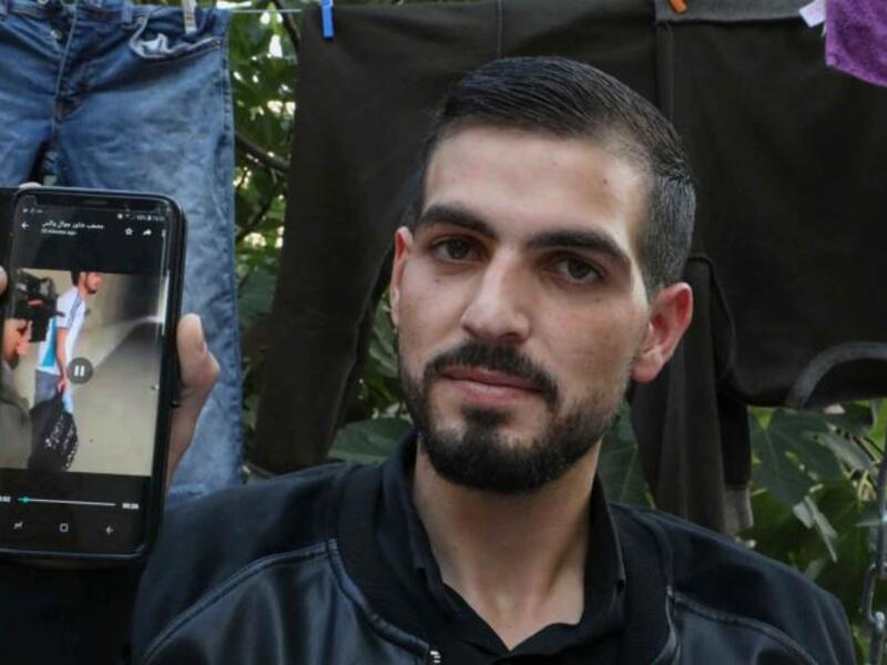 Palestinian Karam al-Qawasmi displays a leaked video showing an Israeli soldier shoot him [AFP/Getty]