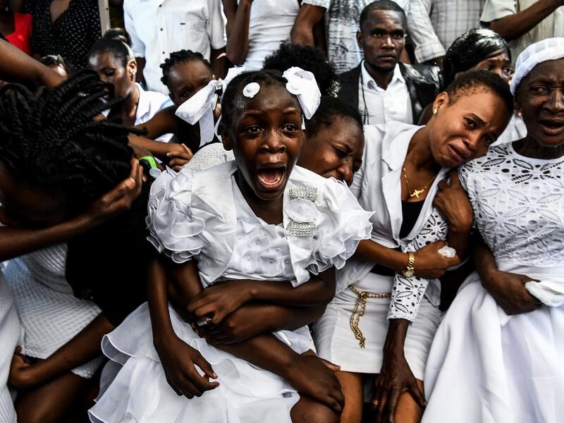 AFP PICTURES OF THE YEAR 2019 - A girl cries during her father's funeral organised by government opposition in Port-au-Prince, Haiti on October 16, 2019. The Haitian opposition on October 9 rejected President Jovenel Moise's appeal for dialogue, as the country's main cities remained paralyzed after more than a month of often violent protests. Over the past year, Haiti has sunk deeper into political crisis as anti-corruption protests demanding Moise's resignation roil the destitute Caribbean nation. CHANDAN 