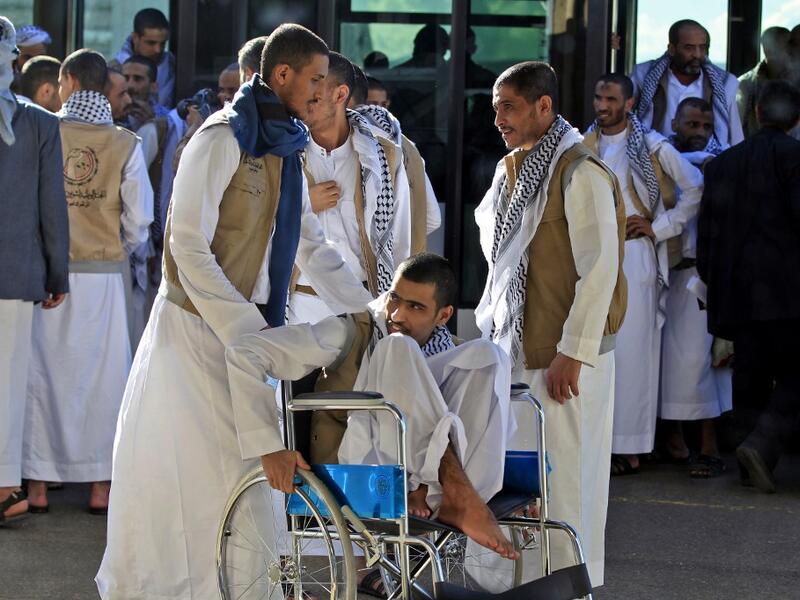A Yemeni Huthi prisoner on a wheelchair is helped by others November 28, 2019, upon his arrival at the airport of the capital Sanaa, following his release, along with other prisoners, by the Saudi-led coalition. (AFP/ File Photo)