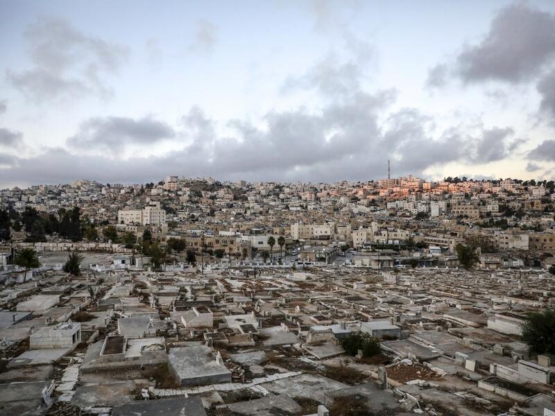 City of Hebron in the occupied West Bank shows a view of a Palestinian cemetery (foreground), an old market building (C) along al-Shuhada street that was newly-announced by the Israeli defence minister to be designated as a new settlement, with existing Israeli settler buildings behind (AFP) 