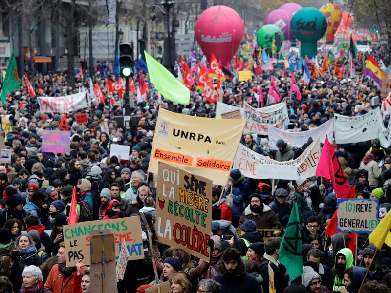 People take part in a demonstration against the pension overhauls, in Paris, on December 5, 2019 as part of a nationwide strike. Trains cancelled, schools closed: France scrambled to make contingency plans on for a huge strike against pension overhauls that poses one of the biggest challenges yet to French President's sweeping reform drive. Thomas SAMSON / AFP