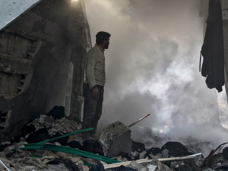 A man stands before a cloud of dust amidst rubble in a collapsed building following a reported air strike in the village of Balyun in Syria's northwestern Idlib province on December 7, 2019.  (AFP/ File Photo)