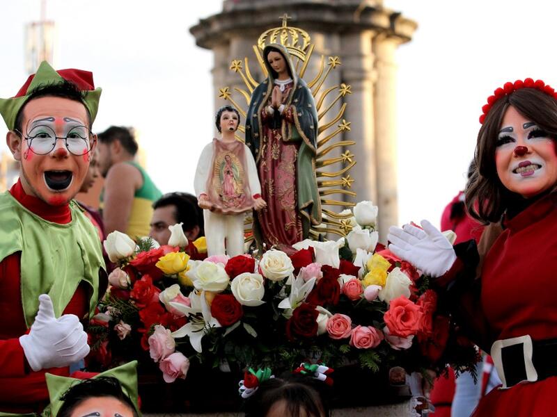 Clowns pose for a photograph with the Virgin of Guadalupe during the International Clown Day in Guadalajara, Mexico, on December 10, 2019. Ulises Ruiz / AFP