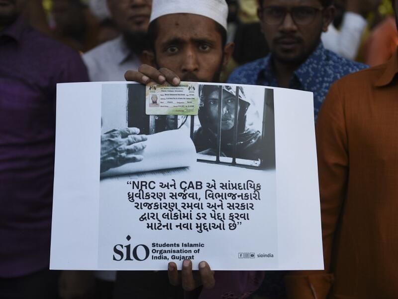 A Muslim man holds a placard as he participates along with others in a peaceful protest against the Citizenship Amendment Bill (CAB) and the National Register of Citizens (NRC) in Ahmedabad on December 15, 2019. Some 5,000 people took part in a fresh demonstration in Guwahati on December 15, with hundreds of police watching on as they sang, chanted and carried banners with the words "long live Assam". SAM PANTHAKY / AFP