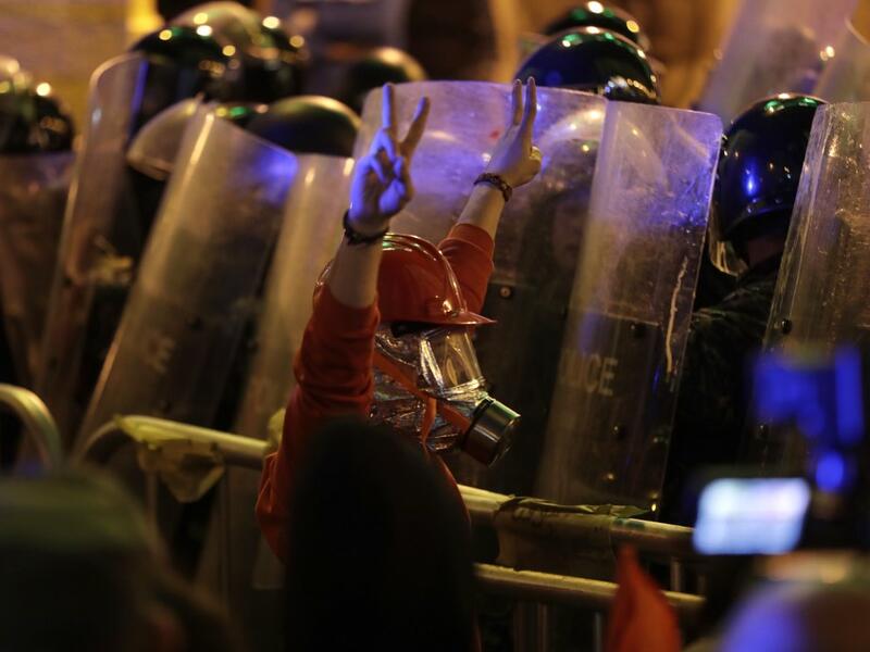 A Lebanese protester wearing protective gear flashes the victory sign at security forces, amid clashes which erupted during an anti-government demonstration in the downtown area of the capital Beirut on December 15, 2019.  (AFP/ File Photo)