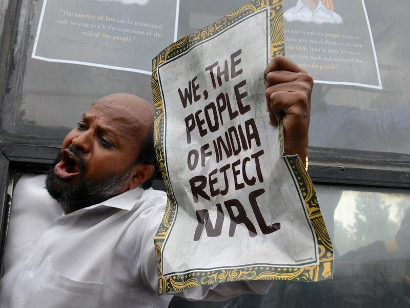 A protester shouts slogans from a bus after being taken into custody by police at the Town Hall during a demonstration held against India's new citizenship law in spite of a curfew in Bangalore (AFP)