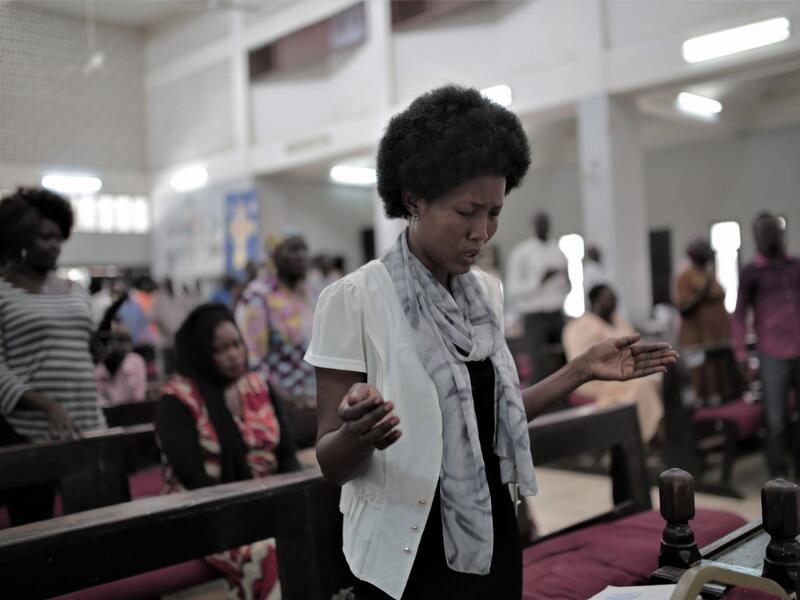 Sudanese Christian woman prays during a Sunday service (AFP)