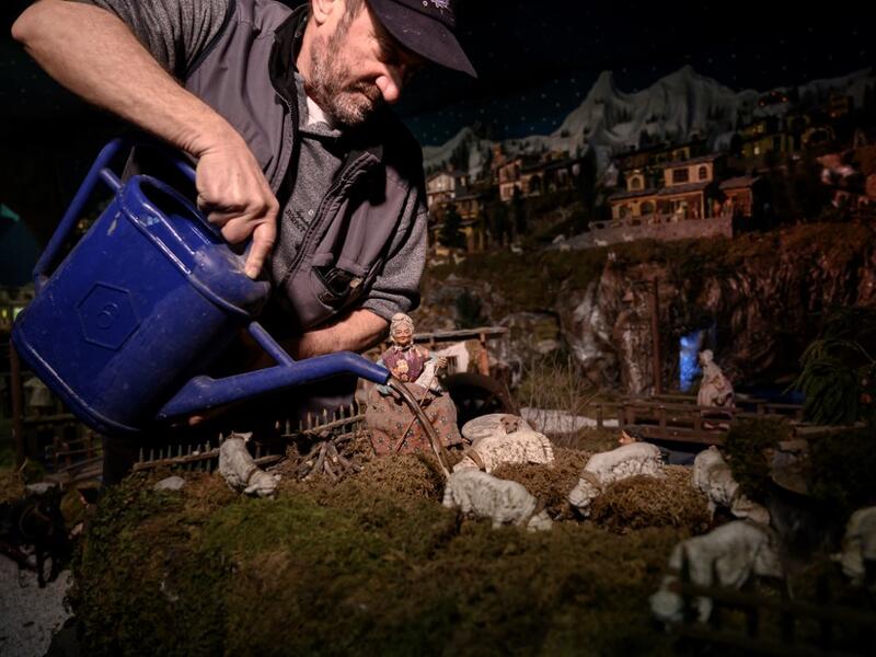 Volunteer Mario Curcetti uses a watering can to set a small river at the 43rd edition of the "Presepio of Cavallermaggiore", a 300sqm Christmas Nativity crib in the Oratorio San Michele on December 20, 2019 in Cavallermaggiore, near Cuneo, Northwestern Italy. The "Presepio" is made by ten volunteers who every year spend 3 months to build a new edition with hundreds of figures. MARCO BERTORELLO / AFP