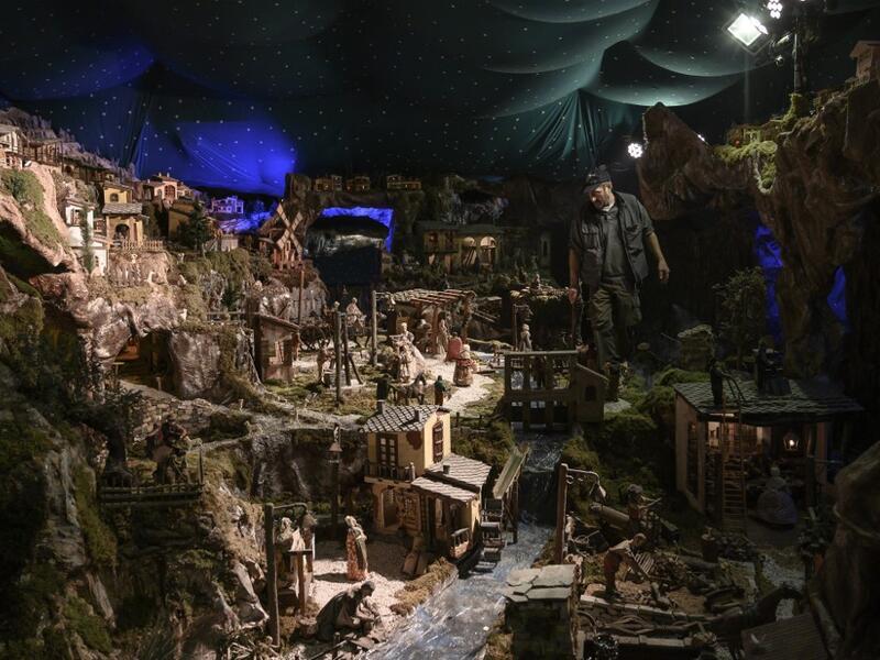 Volunteer Mario Curcetti walks through the "Presepio of Cavallermaggiore", a 300sqm Christmas Nativity crib in the Oratorio San Michele at its 43rd edition on December 20, 2019 in Cavallermaggiore, near Cuneo, Northwestern Italy. The "Presepio" is made by ten volunteers who every year spend 3 months to build a new edition with hundreds of figures. MARCO BERTORELLO / AFP