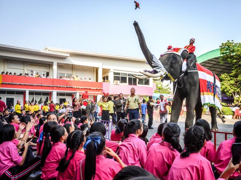 An elephant dressed in a Santa Claus costume presents gifts to schoolchildren during Christmas celebrations in Ayutthaya on December 23, 2019. Wearing red and white hats and a string of bells, Thai elephants passed out Christmas gifts to hundreds of schoolchildren on Monday despite growing criticism over using the animals in performances. The annual festive event is organised by a nearby elephant park, whose mahouts or handlers started in the early morning dressing the animals. Thailand is largely Buddhist 