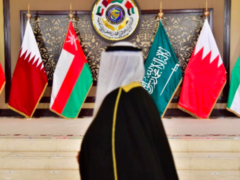 A man walks past the flags of the countries attending the Gulf Cooperation Council summit at Bayan palace in Kuwait City on 5 December (AFP)