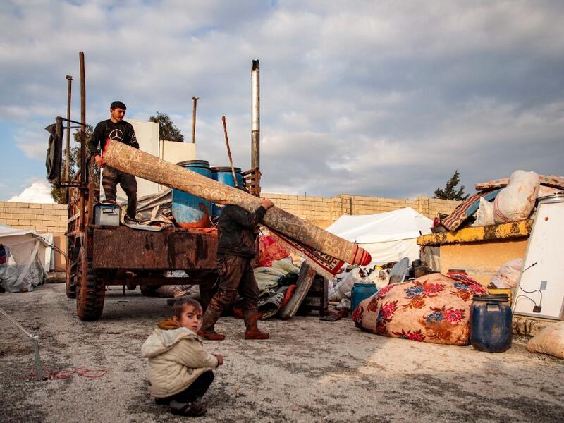 Syrians, among those who fled from government forces' advance on Maaret al-Numan in the south of Idlib prvoince, unload a rolled-up carpet from a truck at a camp for the displaced near the town of Dana in the province's north near the border with Turkey, on December 27, 2019. Aaref WATAD / AFP