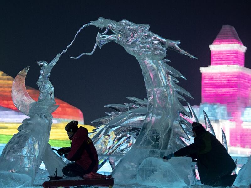 Ice sculptors give finishing touches on an ice sculpture ahead of the opening of the Harbin International Ice and Snow Festival in Harbin, in China's northeast Heilongjiang province on January 3, 2020. NOEL CELIS / AFP